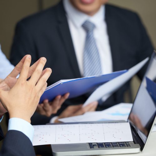 Financial reports on opened laptop of businessman